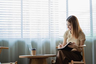 Dost canlısı ve mutlu Asyalı kadın dizüstü bilgisayar kullanıyor ve sohbet ediyor. Video konferansı, evde online iş görüşmesi, internet üzerinden özel ders..