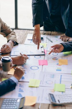 Finans grafik analizi, hesap makinesi ve bilgisayarla birlikte bütçe ve krediyi hesaplamak için kalem beyin fırtınası yapan bir grup iş adamı. Yatırım. Dikey resim.