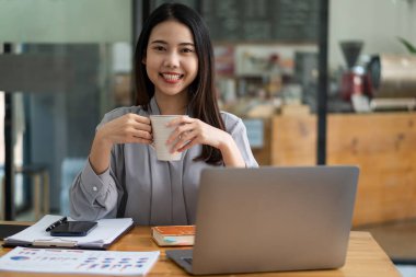 Dizüstü bilgisayarla çalışan Asyalı iş kadını, hesapla, analiz et, genç kadın, mali danışman, istatistiksel rapor hazırla, belgeleri incele, ofisteki mali tablolara bak.
