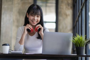 Kafe işletmelerinde dizüstü bilgisayarda çalışan Asyalı güzel bir kadın, dinlenme ve bağımsız çalışma ve iş dünyasının finansal başarısı için mola veriyor.