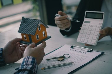 Emlakçı ve müvekkil ev satın alma anlaşmasını tartışıyor. Ya da emlak kredisi işadamı elinde bir kağıt parçası üzerine tükenmez kalem tutuyor.