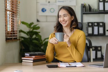 Muhasebe işleriyle ilgilenen Asyalı iş kadını. İnternetteki muhasebe grubu toplantısı ve ofiste kendine güveni olan dizüstü bilgisayar çalışanları kullanıyor.