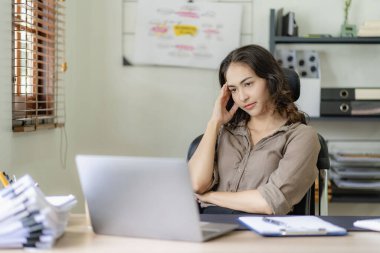 Muhasebe işleriyle ilgilenen Asyalı iş kadını. İnternetteki muhasebe grubu toplantısı ve ofiste kendine güveni olan dizüstü bilgisayar çalışanları kullanıyor.