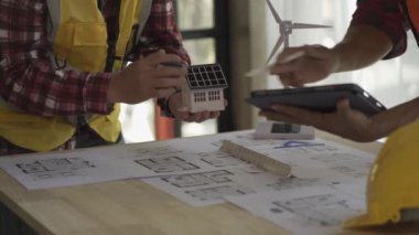 Mimarlar, mühendisler, alternatif enerji rüzgar türbini kurulum planlama planları, toplantı odasında rüzgar enerjisi üretimi ve rüzgar türbini kurulumunu tartışmak üzere toplantı.