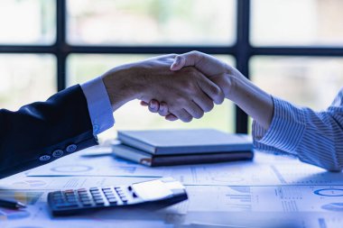 Modern bir konferans salonunda müşterilerle tokalaşan iş adamları takım lideri, birbirlerini selamlamak için grupla tanışır. Güven ve saygı gösteren el sıkışma, finansal muhasebe kavramı