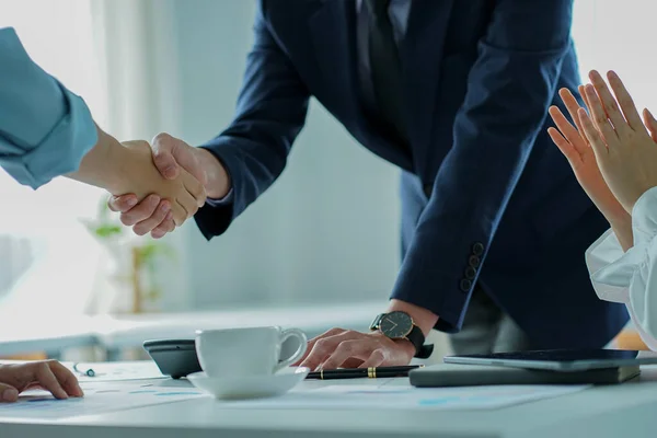 business people shaking hands with customers in a modern conference room The team leader meets the group to greet each other. Handshake showing trust and respect, financial accounting concept