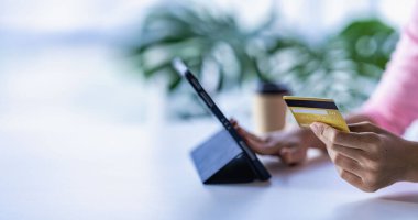 İş kadını kredi kartını elinde tablet ile online alışveriş yapıyor kredi kartı tutan çekici bir kadın ve internet üzerinden ve internet üzerinden akıllı telefon ile alışveriş yapıyor.