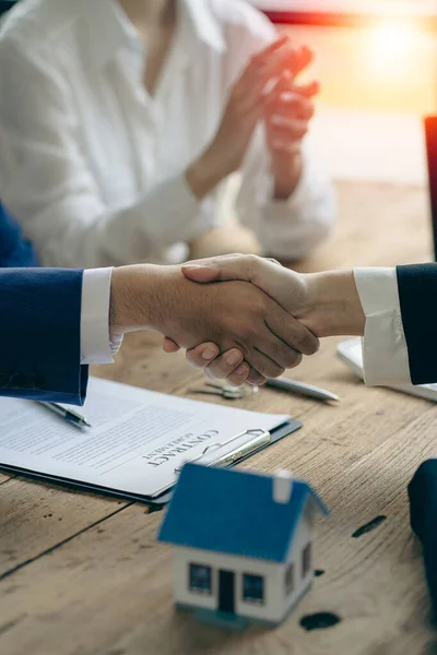 Buyers and real estate agents agree to trade in handshake to rent or buy a home after signing a contract. Businessman congratulates buyer after agreeing to insure and buy house project, insurance