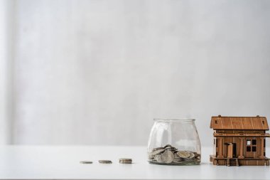 Emlak vergisi ve piyasa büyüme paraları. Tasarruflarını göstermek için ahşap masanın üzerinde para yığınları var. Aile planı. - Ev. Borç. Para yatırımı kavramı beyaz arkaplanda izole edildi.