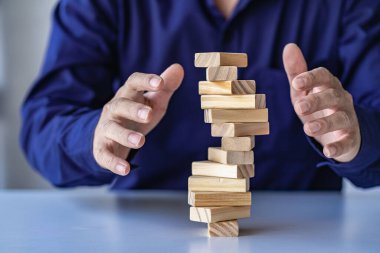 Risk yönetimi kavramları Eller 'in ufalanan tahta blokları korumaya çalışması kule işadamı dikkatle yüksek kuleye tahta bloklar yerleştirmesi ve yüksek tahta kuleyi savunması da çok riskliydi..