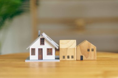 Masanın üzerindeki ahşap ev. Arka planda bulanık bir ev..