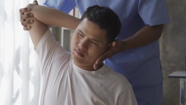 Молодой Человек Проводит Физиотерапию Тренером Физиотерапия Реабилитация Травм Физиотерапевтом Помощь — стоковое видео