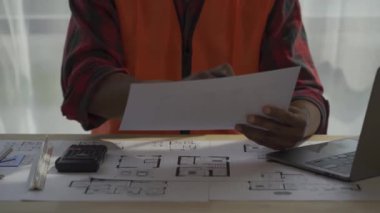 Mimar ve ustabaşı inşaat alanının planlarına bakıyor ve inşaatı planlıyor. Mühendisler çözüm üretmek için beyin fırtınası yapıyor. Başarılı bir geliştirme stratejisi planla.