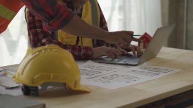 Mimar ve ustabaşı inşaat alanının planlarına bakıyor ve inşaatı planlıyor. Mühendisler çözüm üretmek için beyin fırtınası yapıyor. Başarılı bir geliştirme stratejisi planla.