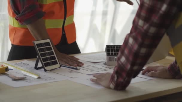 一位工头或领头人在建筑工地讨论家庭太阳能农场和风力涡轮机模型 — 图库视频影像