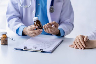 Doktor, klinikteki hastayla konuşuyor. Kadın hasta, hastane koltuğunda oturup doktorlara sağlık sorununu anlatıyor. Danışman konsepti.