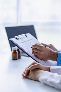 Doktor, klinikteki hastayla konuşuyor. Kadın hasta, hastane koltuğunda oturup doktorlara sağlık sorununu anlatıyor. Danışman konsepti.