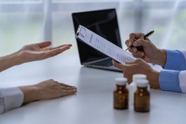 Doktor, klinikteki hastayla konuşuyor. Kadın hasta, hastane koltuğunda oturup doktorlara sağlık sorununu anlatıyor. Danışman konsepti.