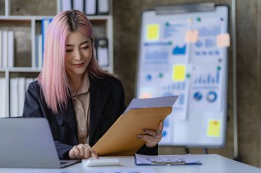 Dizüstü bilgisayar ve mali belgelerle çalışan genç Asyalı kadın çalışan, mali muhasebe kavramı