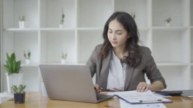 Kağıt, çizelge, grafik ve hesaplama giderlerine bakan iş kadını, istatistik ve hesap makinesiyle mali harcamalara bakan kız, ofiste çalışan kız, dizüstü bilgisayar üzerinde çalışırken mali analiz