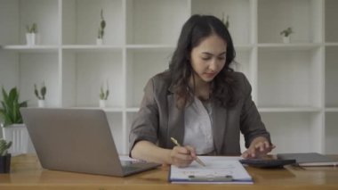 Kağıt, çizelge, grafik ve hesaplama giderlerine bakan iş kadını, istatistik ve hesap makinesiyle mali harcamalara bakan kız, ofiste çalışan kız, dizüstü bilgisayar üzerinde çalışırken mali analiz