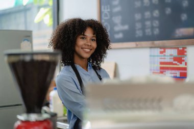 Gülümseyen Afro-Amerikan kahveci kahve tezgahının arkasında durup müşteri, yiyecek ve içecek konseptini kabul ediyor.