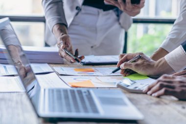 Bir grup Asyalı iş adamı birlikte çalışmak için beyin fırtınası yapıyorlar. Paylaşım, arayış eğilimleri kaynakları paylaşın, iş sorunlarını çözün, şirketteki performansı değerlendirin.