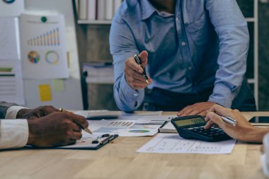 Bir grup Asyalı iş adamı birlikte çalışmak için beyin fırtınası yapıyorlar. Paylaşım, arayış eğilimleri kaynakları paylaşın, iş sorunlarını çözün, şirketteki performansı değerlendirin.