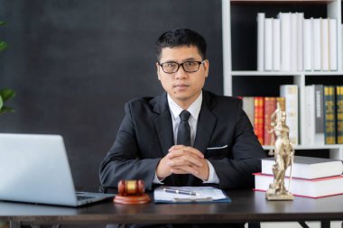 Asyalı erkek avukat çekiç ve teraziyle çalışıyor. Adalet Tanrıçası, kolluk kuvveti, hâkim çekici, davanın kanıtı olarak kabul edilen belgeler, online hukuk danışmanı..