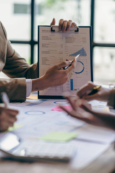 Команда деловых людей, держащих ручку, указывая на штрих-чарт на встрече финансовых документов компании, группа деловых людей вместе концептуальный вертикальный имидж