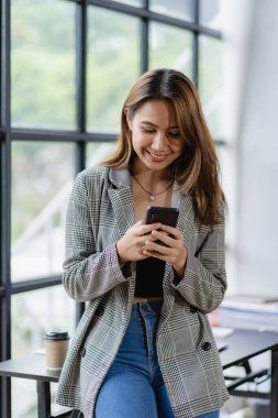 Happy Asian female employees working in modern large office company manager Professional businessman or employee using laptop talking on the phone. vertical image