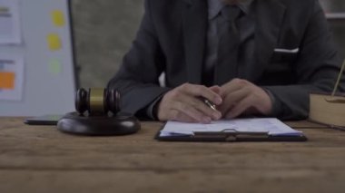 Unknown lawyer working with documents and legal books, golden scales and hammer in courtroom or office There is justice and law, lawyer or court judge 4k.