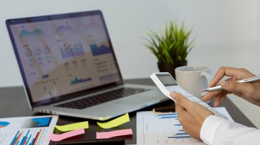 Hand of a business man using a calculator to check financial accounts, check expenditures and company budget. Female accountant calculating while working analyzing business reports at work