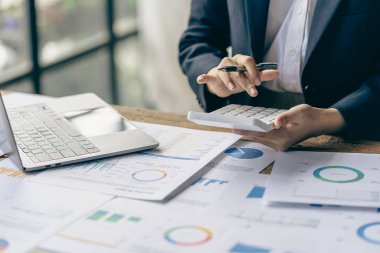 Hand of a business man using a calculator to check financial accounts, check expenditures and company budget. Female accountant calculating while working analyzing business reports at work