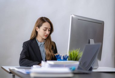 Asian businesswoman working with laptop computer and calculator financial documents on table make a plan analyzing financial reports business plan investment in the office