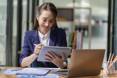Asian businesswoman working with laptop computer and calculator financial documents on table make a plan analyzing financial reports business plan investment in the office
