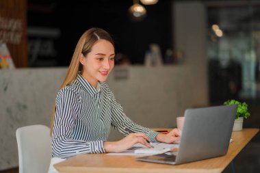 Asian businesswoman working with laptop computer and calculator financial documents on table make a plan analyzing financial reports business plan investment in the office
