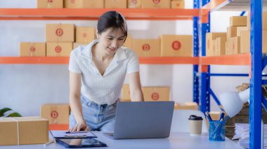 Asian girl using laptop and working at home Entrepreneurs, small businesses, start-ups, delivery boxes, online marketing, SMEs.
