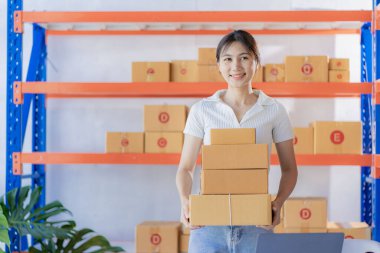 Asian girl using laptop and working at home Entrepreneurs, small businesses, start-ups, delivery boxes, online marketing, SMEs.