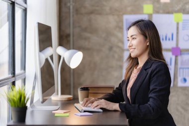 Asian businesswoman working with calculator to analyze business data and financial concept Female accountant working with computer and for business and financial expenses charming asian girl