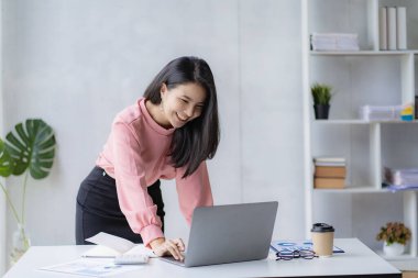 Asian businesswoman working with calculator to analyze business data and financial concept Female accountant working with computer and for business and financial expenses charming asian girl