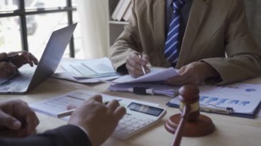 Sales department has a monthly briefing meeting to present to the manager to verify the accuracy of the documents prepared before submitting them to the manager with a hammer next to the finance approval concept.