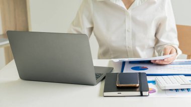 Businessman hands on keyboard of laptop computer showing data analysis graph Businessman working and analyzing financial figures on graph document