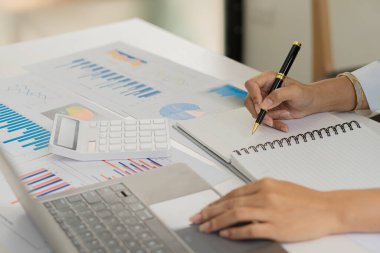 Businessman hands on keyboard of laptop computer showing data analysis graph Businessman working and analyzing financial figures on graph document