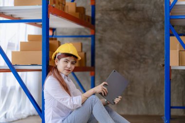 Young Asian woman checking parcels for delivery taking orders with small business laptop. SME business owners check orders online Prepare to pack products for sale to customers, SME business ideas