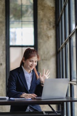 Asian businesswoman working on laptop computer in office Freelance online marketing employee on telemarketing concept online meeting concept vertical image