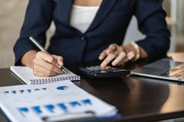 Business woman accountant, office worker working on desk, hand pressing calculator to calculate business profit and loss, calculating budget, income. Expense of credit card for payment on table.