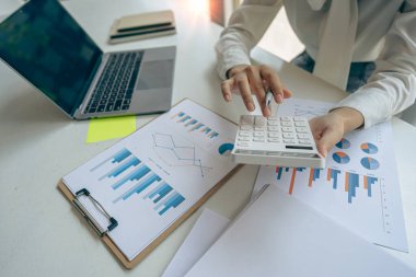 Business woman accountant, office worker working on desk, hand pressing calculator to calculate business profit and loss, calculating budget, income. Expense of credit card for payment on table.