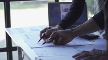 Asian businessman close-up brainstorming analytical calculation plan meeting and team leader pointing graph and note taking worker with laptop on table The concept of business success statistics. 4k