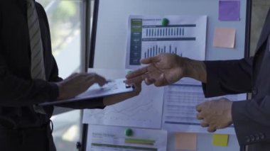 Asian businessman close-up brainstorming analytical calculation plan meeting and team leader pointing graph and note taking worker with laptop on table The concept of business success statistics. 4k